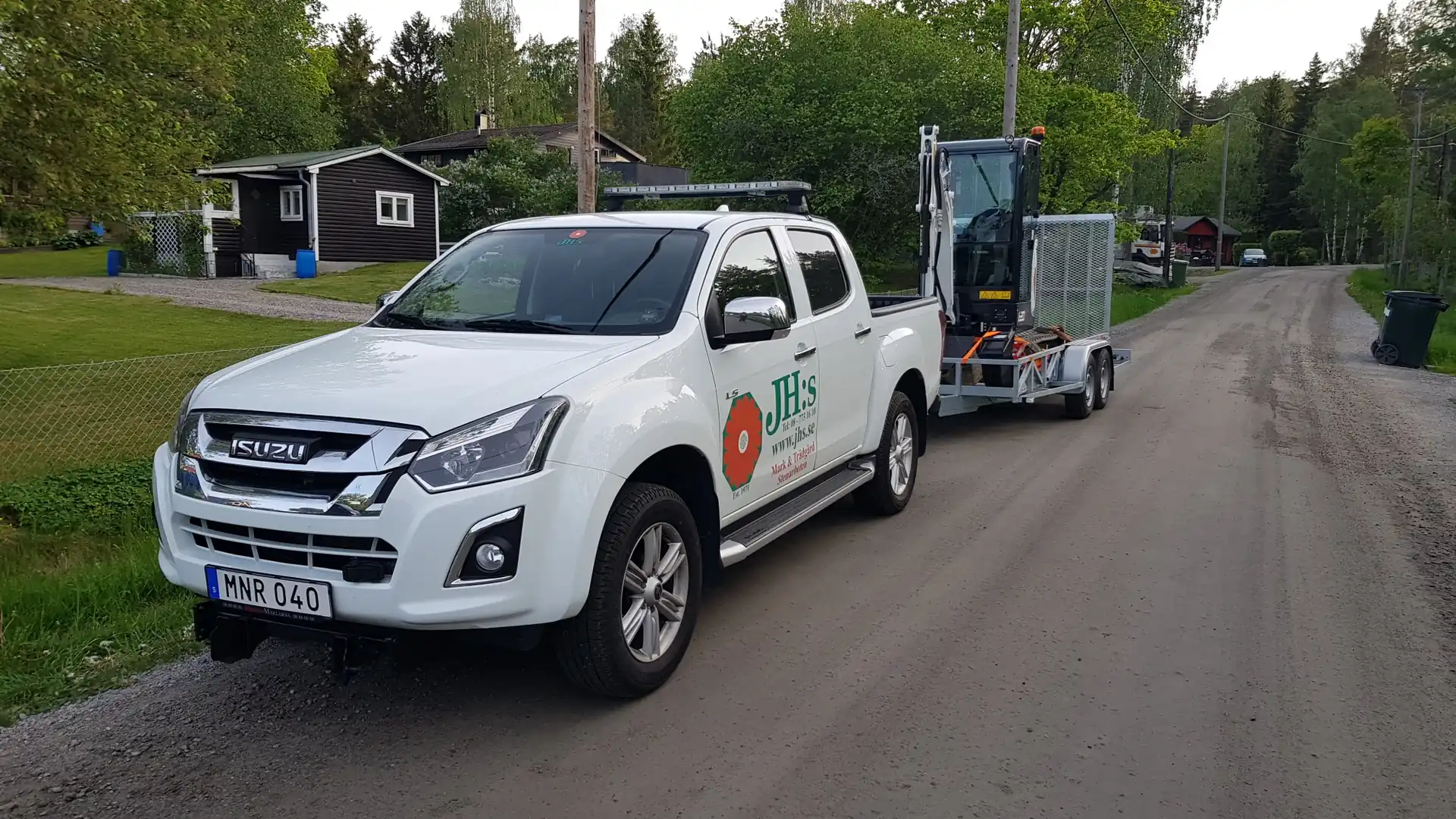 JH:s servicebil med grävmaskin på släp